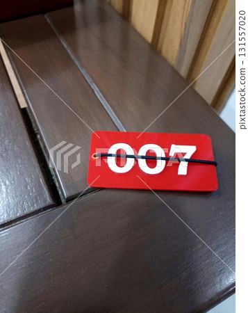 Lucky Number 007 Tag on Wooden Surface 131557020
