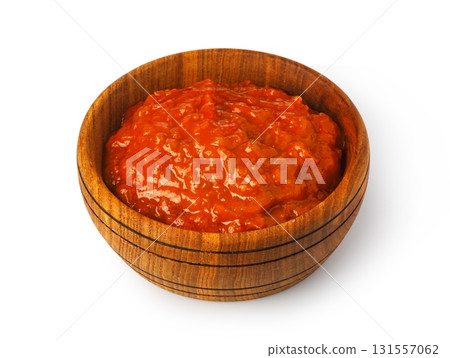 Red pepper sauce in wooden bowl on white background Red pepper sauce in wooden bowl on white background 131557062
