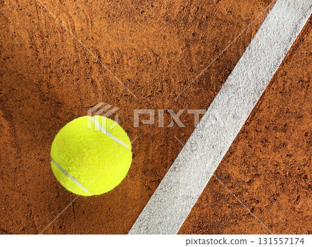 Freeze Motion Detail Shot of Tennis Ball Hitting a Clay Court 131557174