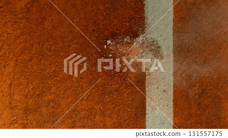 Freeze Motion Detail Shot of Tennis Ball Hitting a Clay Court 131557175