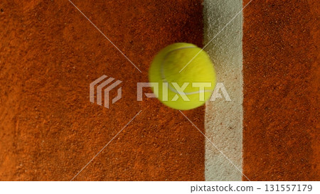 Freeze Motion Detail Shot of Tennis Ball Hitting a Clay Court Freeze Motion Detail Shot of Tennis Ball Hitting a Clay Court 131557179