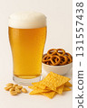 Glass of beer with pretzels chips and peanuts 131557438