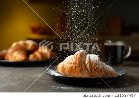 Croissants sprinkled with sugar powder. 131557497