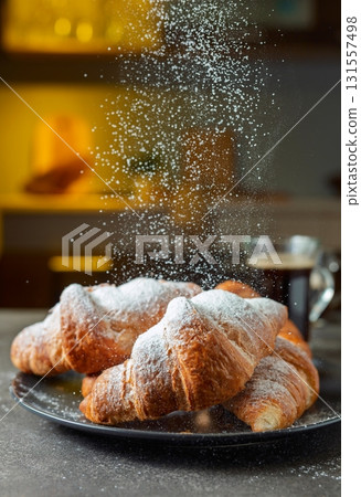Croissants sprinkled with sugar powder. 131557498