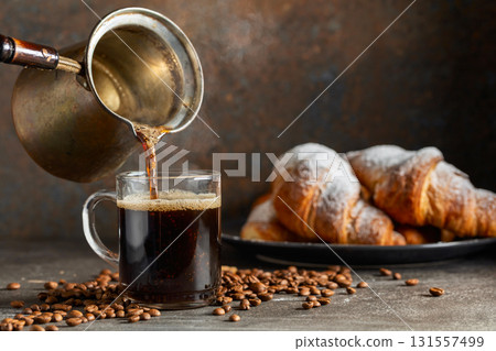 Croissants and black coffee on a kitchen table. 131557499