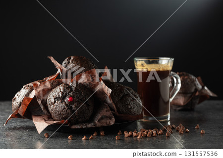 Dark chocolate muffins and cup of black coffee. Dark chocolate muffins and cup of black coffee. 131557536