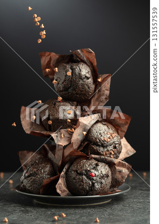 Dark chocolate muffins on a black background. 131557539