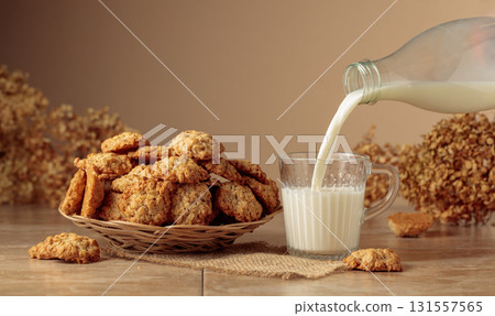 Oatmeal cookies and milk sit on a kitchen table. Oatmeal cookies and milk sit on a kitchen table. 131557565
