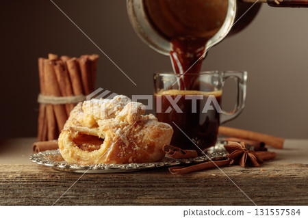 Viennese strudel and black coffee on an old wooden table. Viennese strudel and black coffee on an old wooden table. 131557584