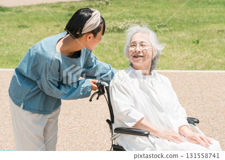 A granddaughter comes for a walk to visit her grandmother who is in a wheelchair 131558741
