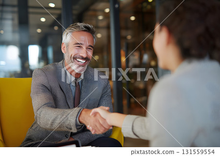 Professional advisor shaking hands with client in positive deal 131559554