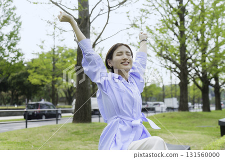 Portrait of a young businesswoman sitting and stretching in a park in an office district Portrait of a young businesswoman sitting and stretching in a park in an office district 131560000