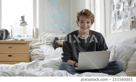 Teenager studying with laptop in bright bedroom, simple interior Teenager studying with laptop in bright bedroom, simple interior 131560801