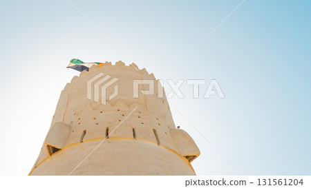 Stone arabic watchtower with waving United Arab Emirates National Flag in Al Jazirah Al Hamra haunted town in Ras Al Khaimah. High quality photo Stone arabic watchtower with waving United Arab Emirates National Flag in Al Jazirah Al Hamra haunted town in Ras Al Khaimah. High quality photo 131561204