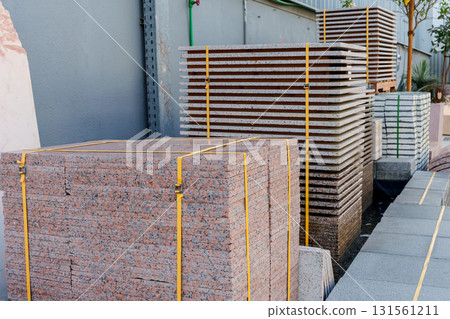 Pallets with stacked gray paving slabs selective focus Stack of paving slabs in warehouse road repair or finished tile sale space for text. High quality photo Pallets with stacked gray paving slabs selective focus Stack of paving slabs in warehouse road repair or finished tile sale space for text. High quality photo 131561211