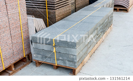 Pallets with stacked gray paving slabs selective focus Stack of paving slabs in warehouse road repair or finished tile sale space for text. High quality photo Pallets with stacked gray paving slabs selective focus Stack of paving slabs in warehouse road repair or finished tile sale space for text. High quality photo 131561214