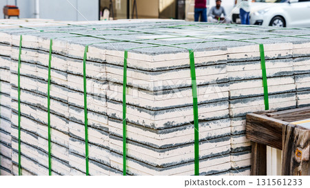 Pallets with stacked gray paving slabs selective focus Stack of paving slabs in warehouse road repair or finished tile sale space for text. High quality photo Pallets with stacked gray paving slabs selective focus Stack of paving slabs in warehouse road repair or finished tile sale space for text. High quality photo 131561233
