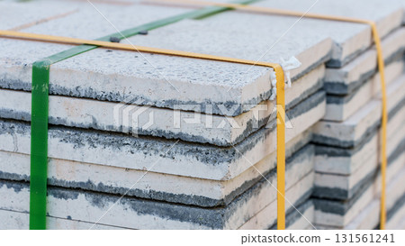Pallets with stacked gray paving slabs selective focus Stack of paving slabs in warehouse road repair or finished tile sale space for text. High quality photo 131561241