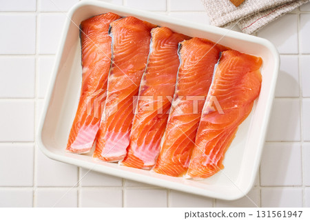 Raw salmon fillets | Cooking ingredients arranged on a white tray (tile background) Raw salmon fillets | Cooking ingredients arranged on a white tray (tile background) 131561947