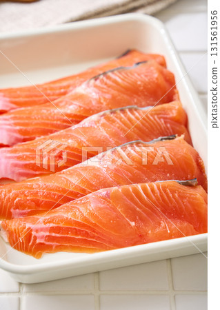 Raw salmon fillets | Cooking ingredients arranged on a white tray (tile background) Raw salmon fillets | Cooking ingredients arranged on a white tray (tile background) 131561956
