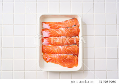 Raw salmon fillets | Cooking ingredients arranged on a white tray (tile background) Raw salmon fillets | Cooking ingredients arranged on a white tray (tile background) 131561960