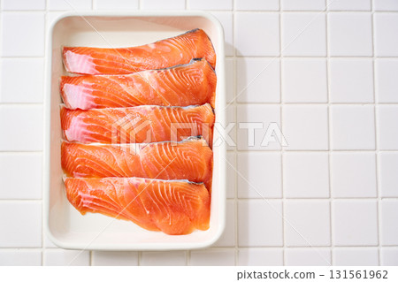 Raw salmon fillets | Cooking ingredients arranged on a white tray (tile background) 131561962