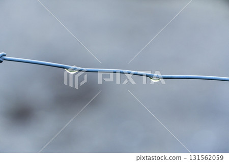 A wire is shown with a droplet of water on it A wire is shown with a droplet of water on it 131562059