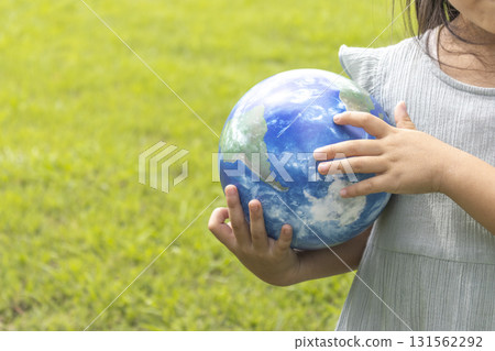 一個女孩站在草地上，手裡拿著地球儀（5歲，日本人，無臉） 131562292