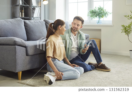 Happy conversation of couple looking to each other, people sitting on floor in home living room 131562319
