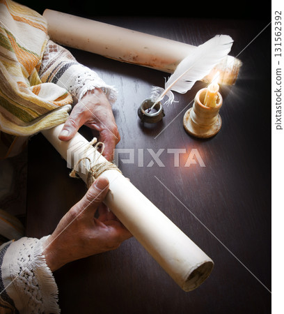 Man holding an old scroll Man holding an old scroll 131562392