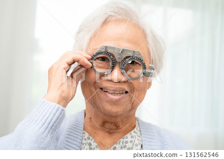 Optometrist checking Asian elderly woman ophthalmic vision eye test and using optical trial frame. Optometrist checking Asian elderly woman ophthalmic vision eye test and using optical trial frame. 131562546
