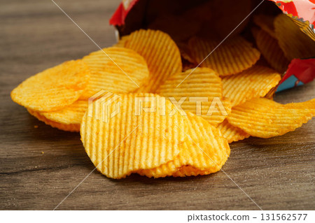 Potato chips in open bag, delicious BBQ seasoning spicy for crips, thin slice deep fried snack fast food. Potato chips in open bag, delicious BBQ seasoning spicy for crips, thin slice deep fried snack fast food. 131562577