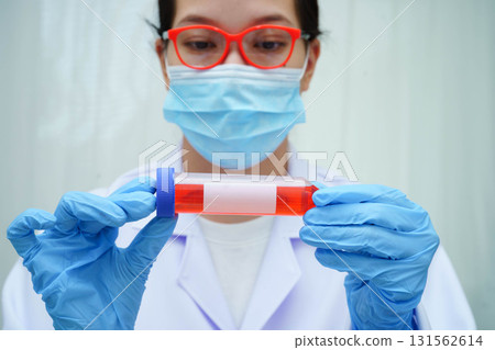 Doctor holding thyroid gland model and blood sample test tube in laboratory. Doctor holding thyroid gland model and blood sample test tube in laboratory. 131562614
