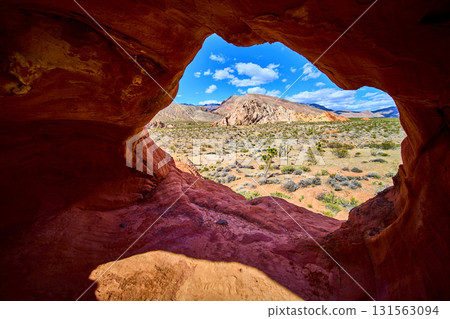 Red Rock Arch Formation with Desert Landscape and Mountains 131563094