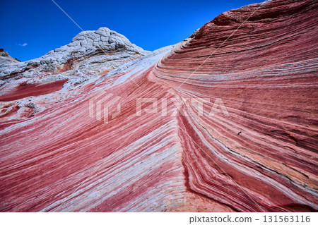 Vivid Striated Sandstone and White Pocket Rock Formation under Clear Blue Sky Vivid Striated Sandstone and White Pocket Rock Formation under Clear Blue Sky 131563116