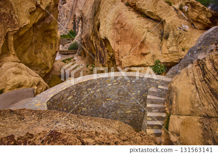 Stone Cistern and Sandstone Cliffs in Desert Canyon Landscape 131563141