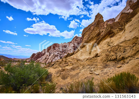 Desert Rock Formations and Vegetation Under Bright Blue Sky Desert Rock Formations and Vegetation Under Bright Blue Sky 131563143
