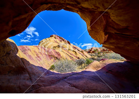 Neapolitan Colored Sandstone Arch Framing Desert Landscape and Blue Sky 131563201
