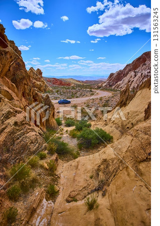 Desert Landscape With Sandstone Formations And Car On Dirt Road In Nevada Desert Landscape With Sandstone Formations And Car On Dirt Road In Nevada 131563245