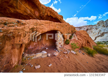 Red Rock Cave and Stone Wall in Desert Landscape Under Blue Sky Red Rock Cave and Stone Wall in Desert Landscape Under Blue Sky 131563347