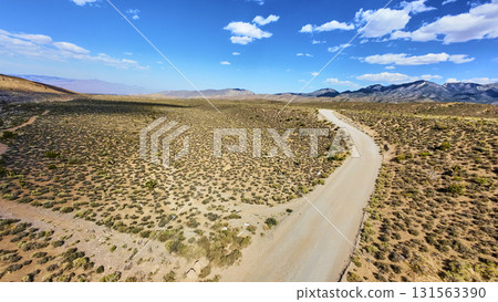 Aerial Desert Road and Mountain Range Near Mt Charleston Nevada Under Blue Sky 131563390