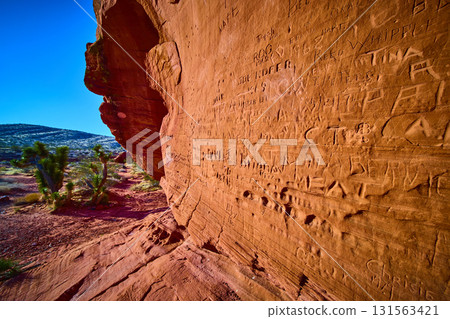 Historic Names Carved Into Red Sandstone Wall In Desert Landscape Historic Names Carved Into Red Sandstone Wall In Desert Landscape 131563421