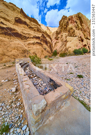 Stone Cistern and Layered Cliffs in Desert Landscape Stone Cistern and Layered Cliffs in Desert Landscape 131563447