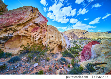 Colorful Sandstone Formations and Desert Vegetation Under Bright Blue Sky Colorful Sandstone Formations and Desert Vegetation Under Bright Blue Sky 131563583