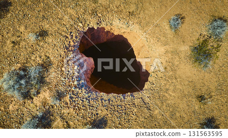 Aerial Sinkhole and Desert Landscape with Sparse Vegetation 131563595