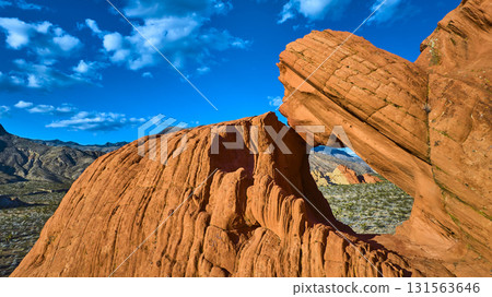 Red Sandstone Arch Formation and Desert Landscape Under Vibrant Blue Sky 131563646
