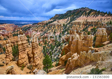 Bryce Canyon Hoodoos Pine Trees and Colorful Cliffs Under Dramatic Sky 131563800
