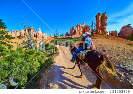 Horseback Rider on Peekaboo Loop Trail with Red Rock Formations and Clear Blue Sky Horseback Rider on Peekaboo Loop Trail with Red Rock Formations and Clear Blue Sky 131563866