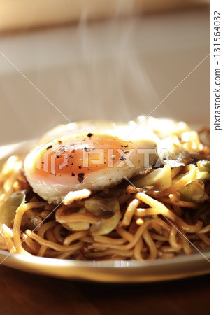 Hot, freshly made yakisoba noodles topped with a fried egg Hot, freshly made yakisoba noodles topped with a fried egg 131564032