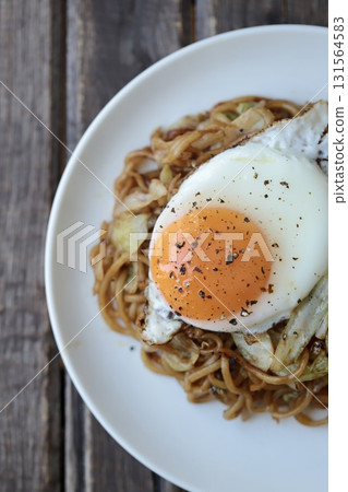Medium-thick yakisoba noodles topped with a fried egg Medium-thick yakisoba noodles topped with a fried egg 131564583